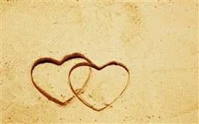 Dos corazones del amor en la arena