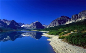Montañas, el lago, la pendiente, el cielo azul, la reflexión