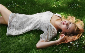 Hermosa hierba mentira muchacha, vestido de blanco, la postura